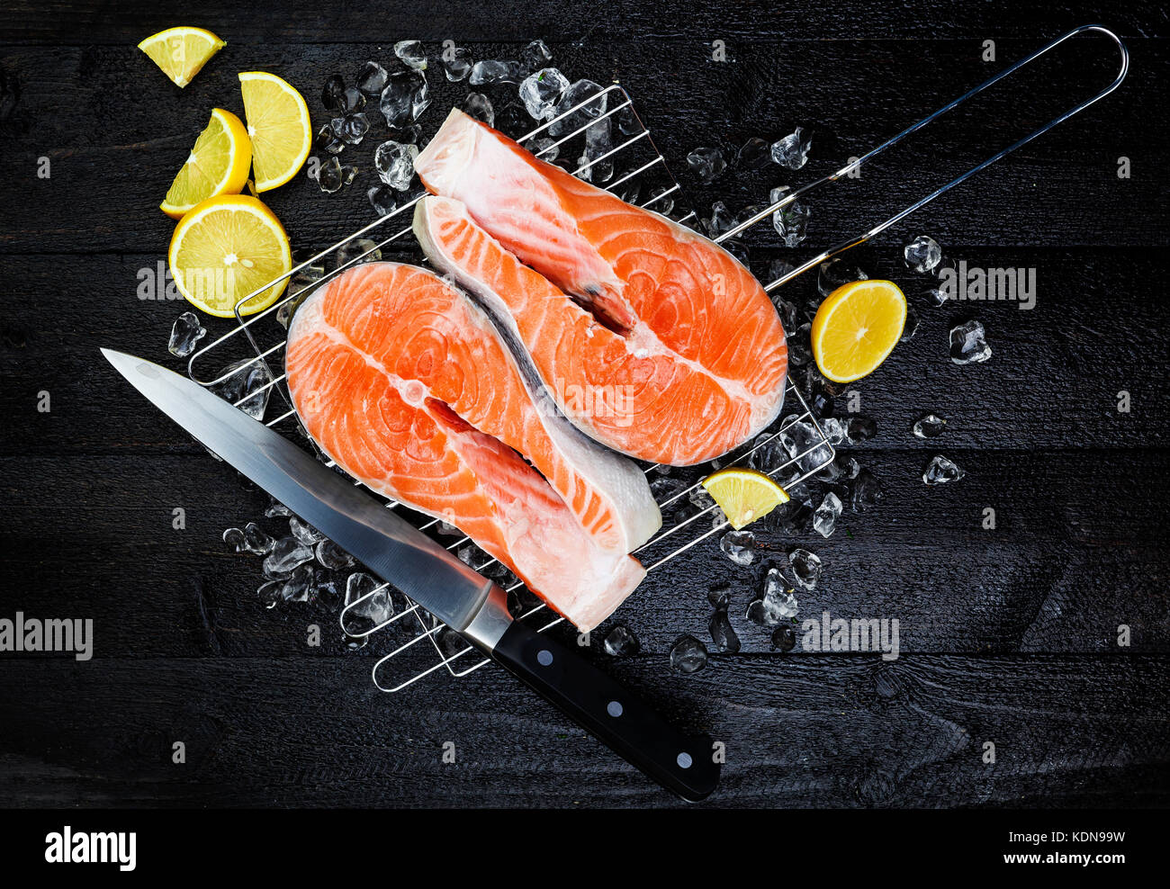 La glace sur les darnes de saumon sur la vue de dessus de table en bois noir Banque D'Images