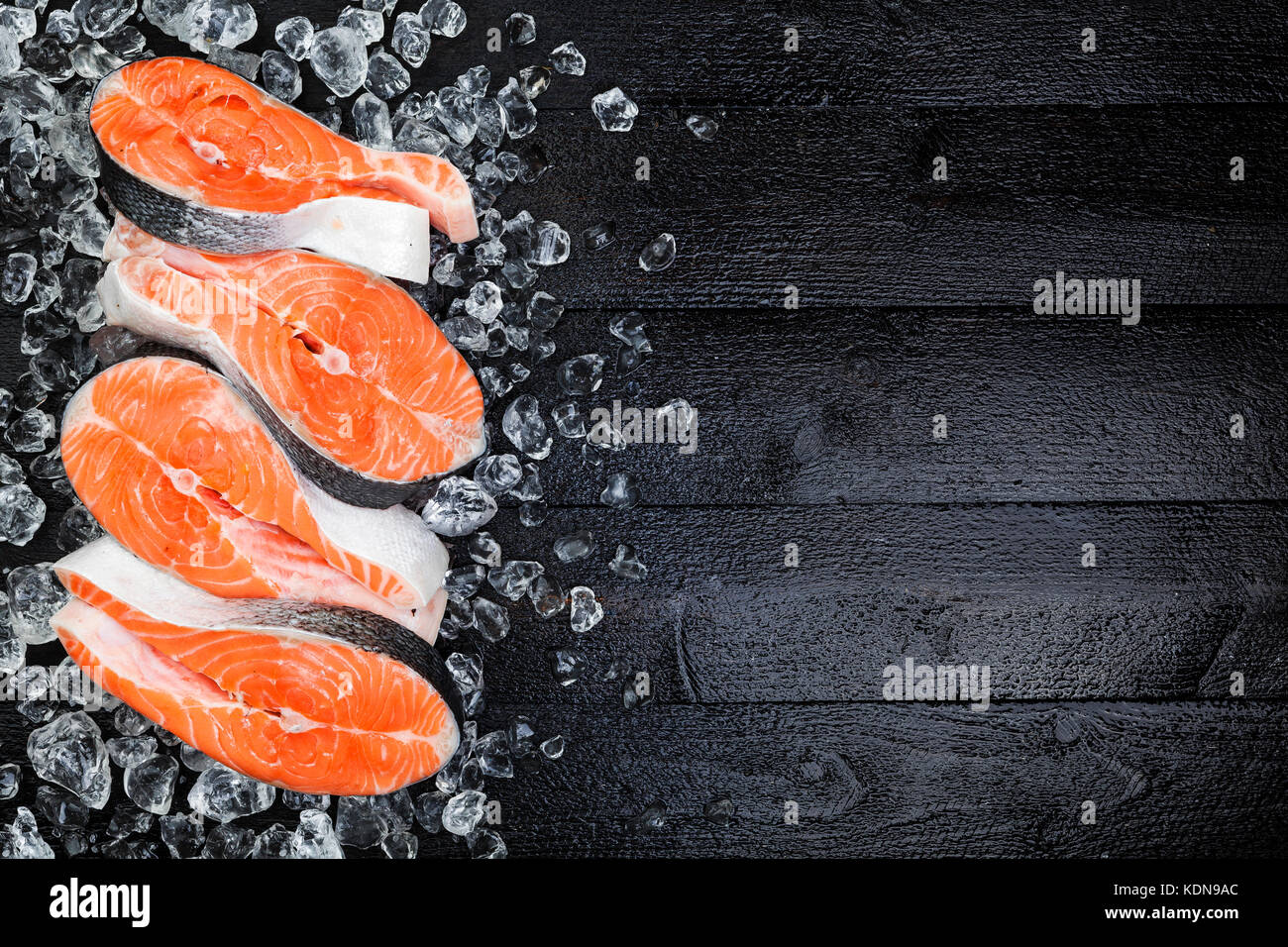 La glace sur les darnes de saumon sur la table en bois noir voir l'espace de copie. Banque D'Images