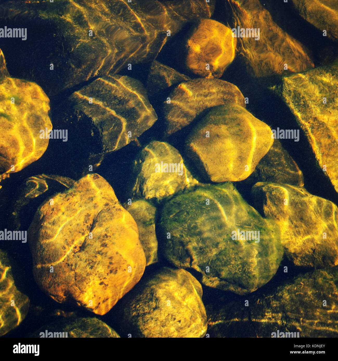 L'eau peu profonde avec des pierres dans le fond. De photo. Le lac Ladoga bas avec des cailloux. Ondulation sur la surface des pierres. Filtre vintage photo. Rock Banque D'Images