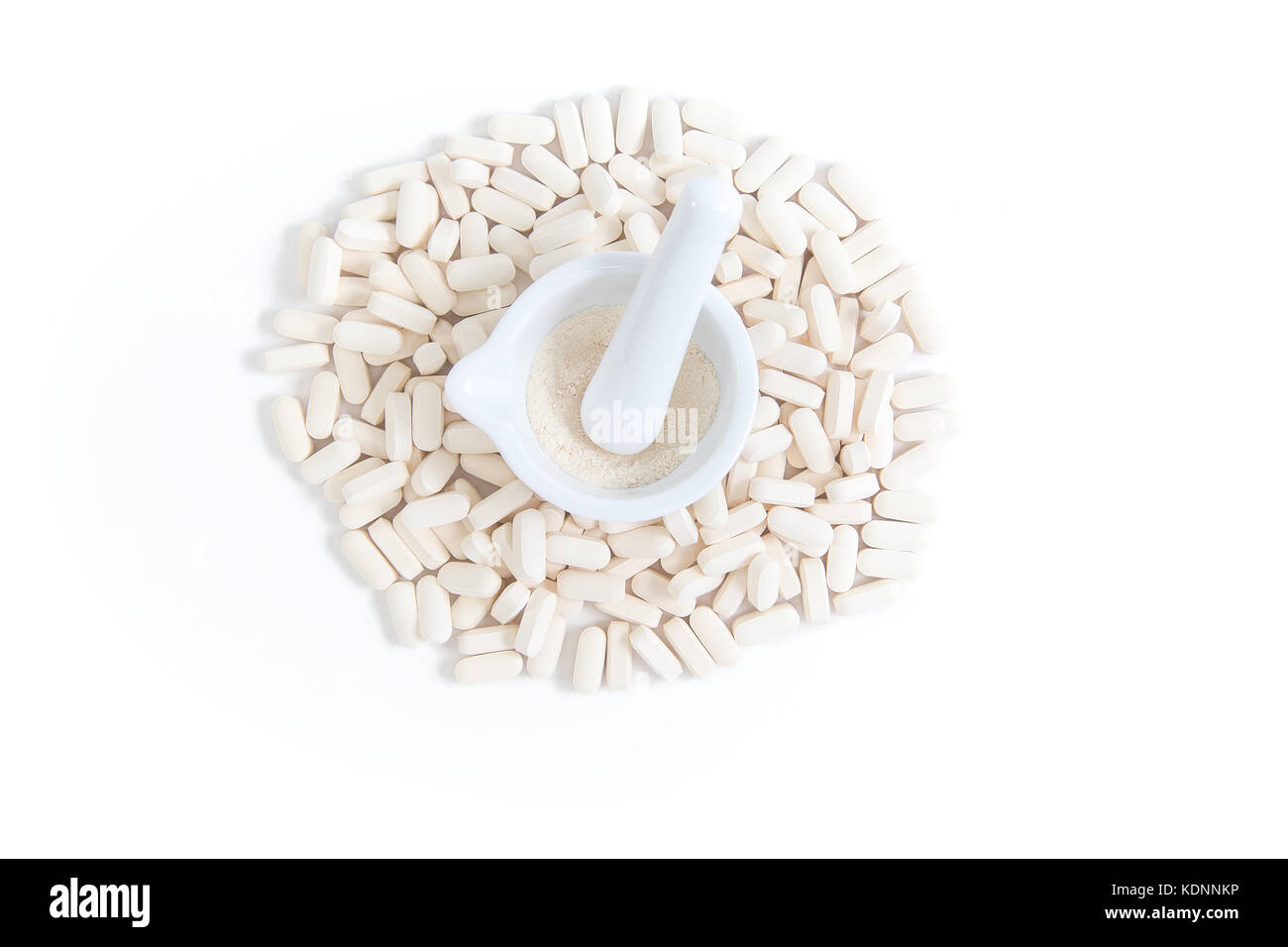 Vue de dessus de pile de circulaires blancs crème, avec un mortier et un pilon sur fond blanc Banque D'Images