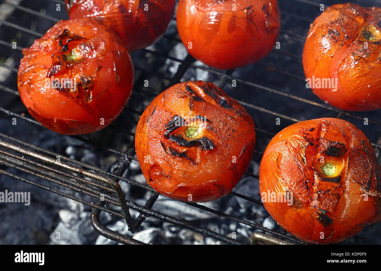Les tomates rouges avec grillemarks la cuisson sur barbecue char avec de la fumée, Close up, high angle view Banque D'Images