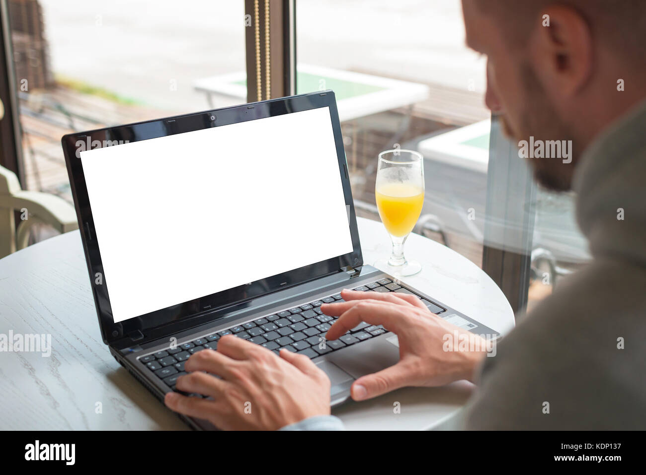 Travailler sur un ordinateur portable dans un café. écran isolé pour une maquette. Banque D'Images