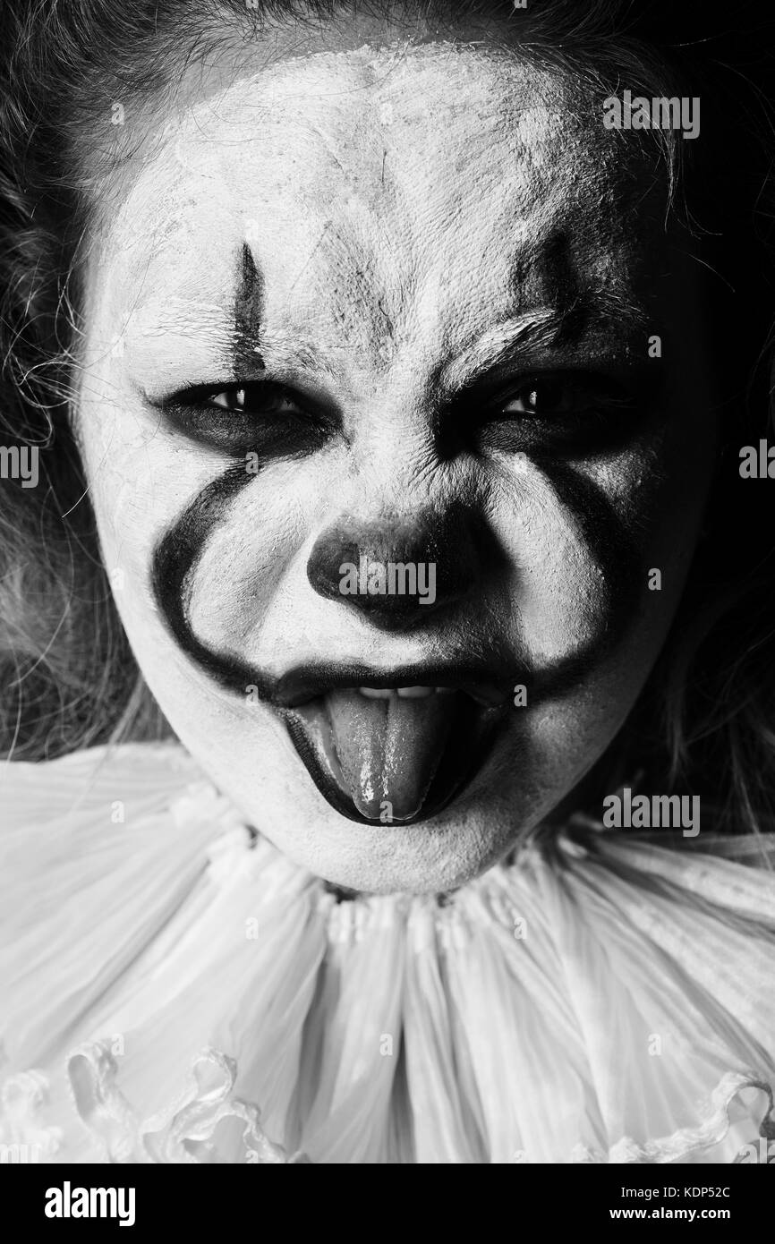 En colère contre le mal clown, montrer la langue à la caméra au close up, monochrome Banque D'Images