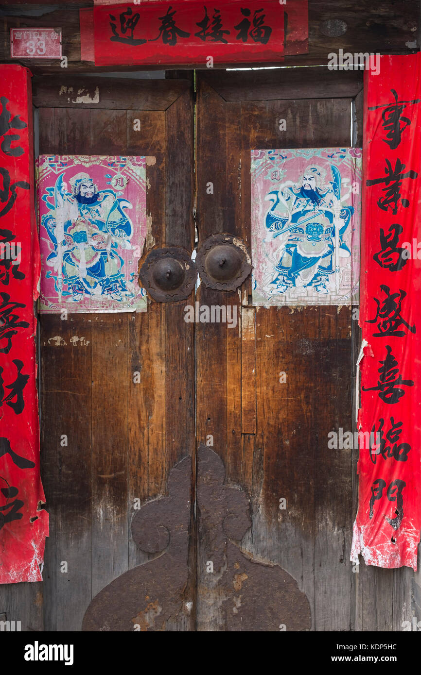 Une vieille porte avec spring festival couplets, chinois portiers et Rusty heurtoirs, dans un hutong de Beijing, Chine.. Banque D'Images