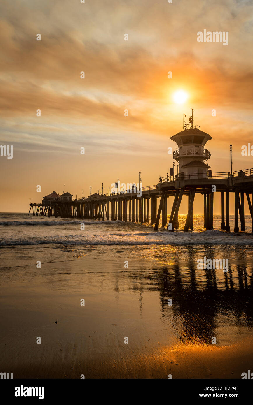 Les feux de forêt locaux sont un pipeline brun doré qui dégage une fumée au-dessus du ciel de la jetée de Huntington Beach, créant ainsi des paysages surréalistes. Banque D'Images