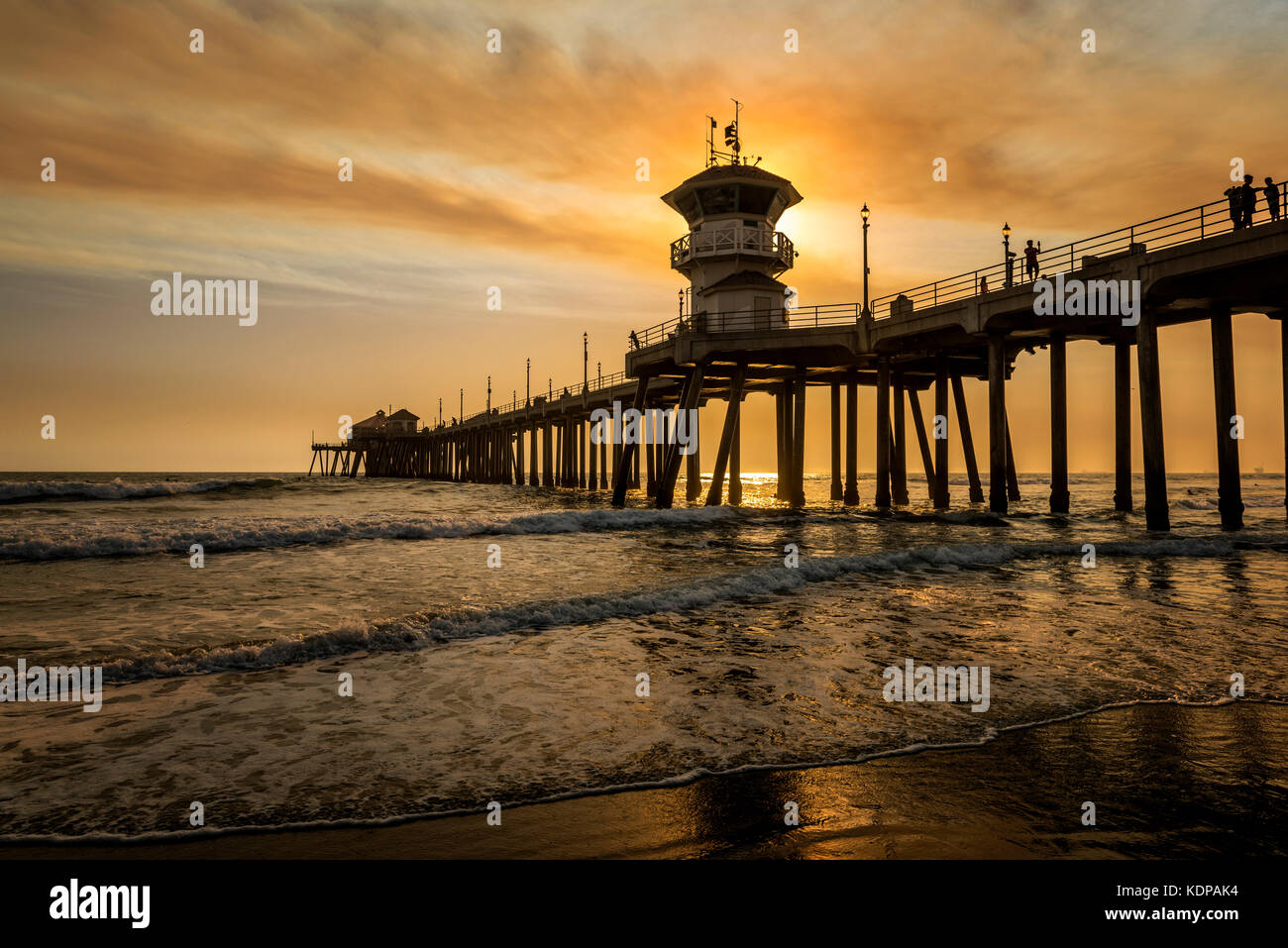 Les feux de forêt locaux sont un pipeline brun doré qui dégage une fumée au-dessus du ciel de la jetée de Huntington Beach, créant ainsi des paysages surréalistes. Banque D'Images