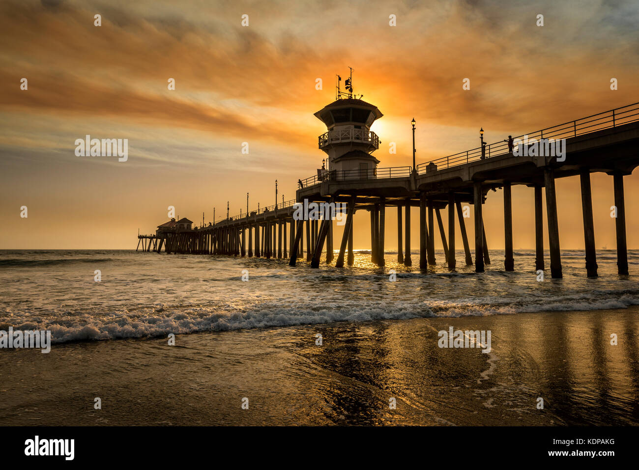Les feux de forêt locaux sont un pipeline brun doré qui dégage une fumée au-dessus du ciel de la jetée de Huntington Beach, créant ainsi des paysages surréalistes. Banque D'Images