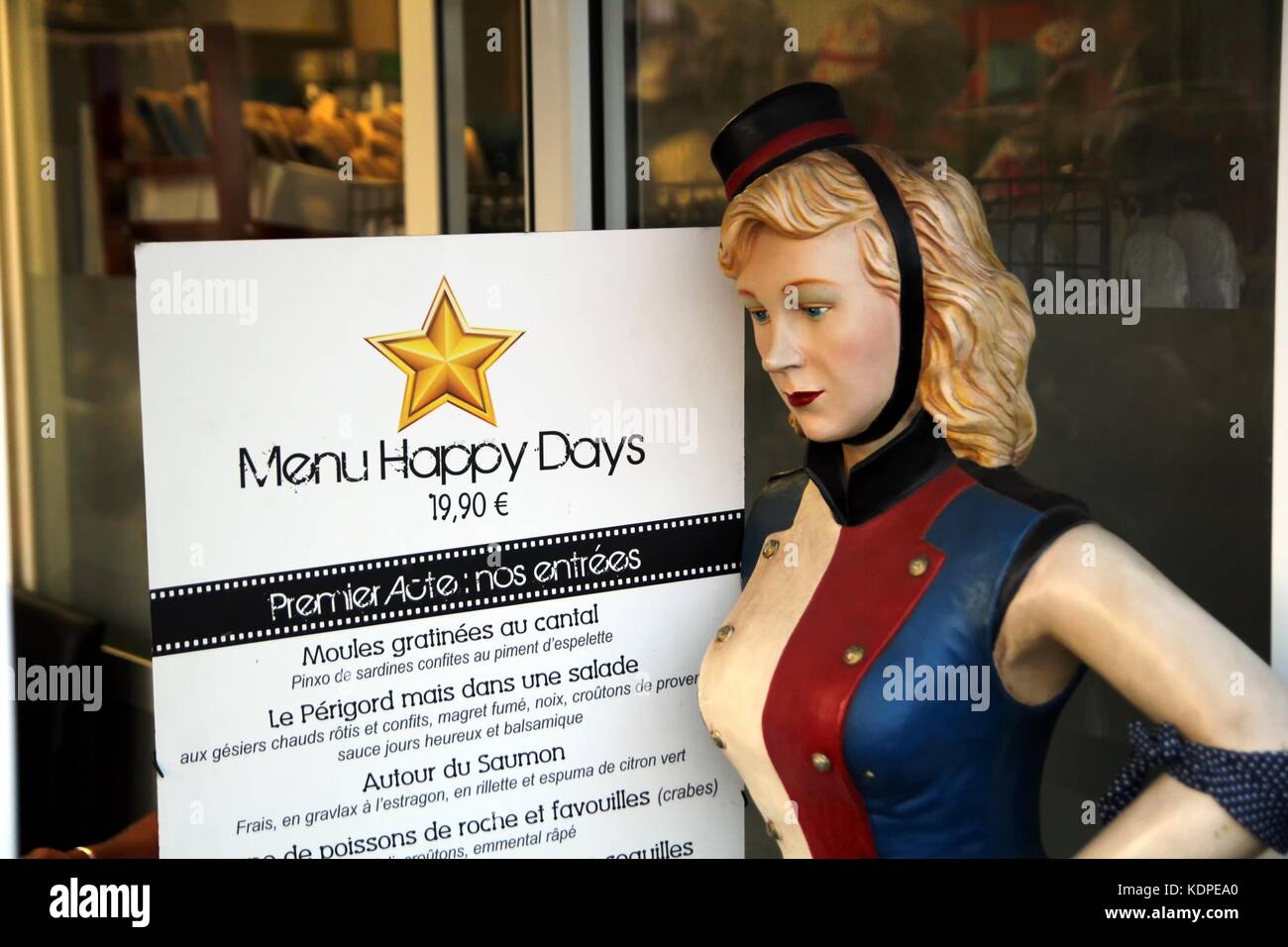Au menu à thème hollywood français 'restaurant les jours heureux, valras-plage', avec un female mannequin habillé en groom de l'hôtel. Banque D'Images