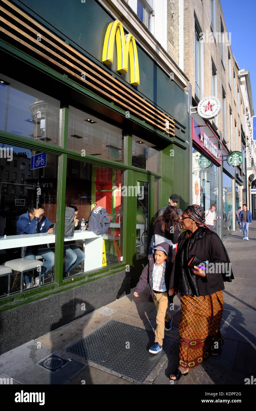 Caraïbes Afrique femme avec enfant à pied adoptée par Mcdonald's Kings Cross, Islington, Londres, Angleterre Banque D'Images