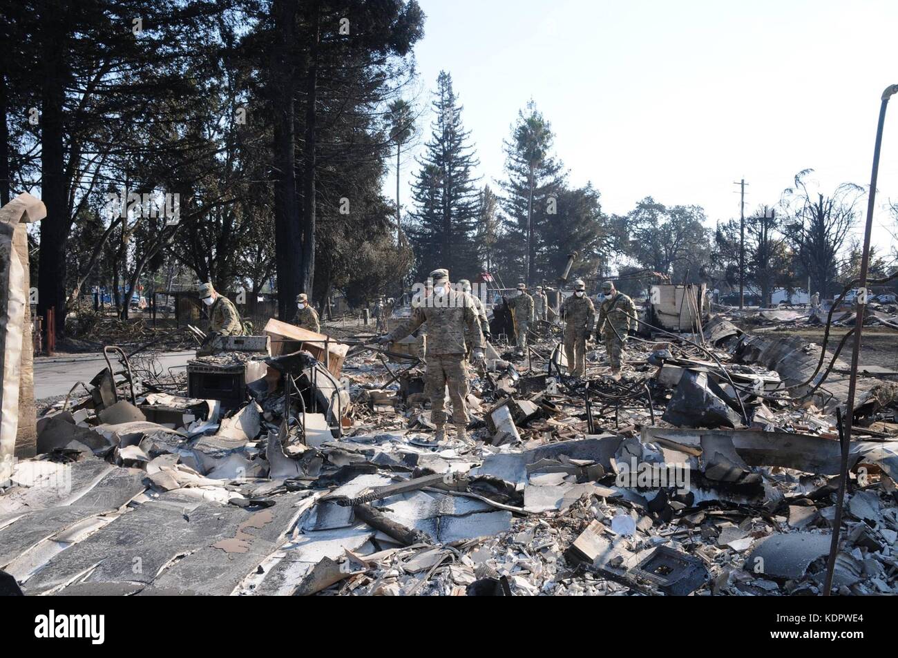 Les soldats de l'armée américaine à partir de la 40e compagnie de police militaire pour la recherche reste des victimes dans les décombres de maisons détruites par les incendies qui balaie le comté de Sonoma, 14 octobre 2017 à Santa Rosa, en Californie. Banque D'Images