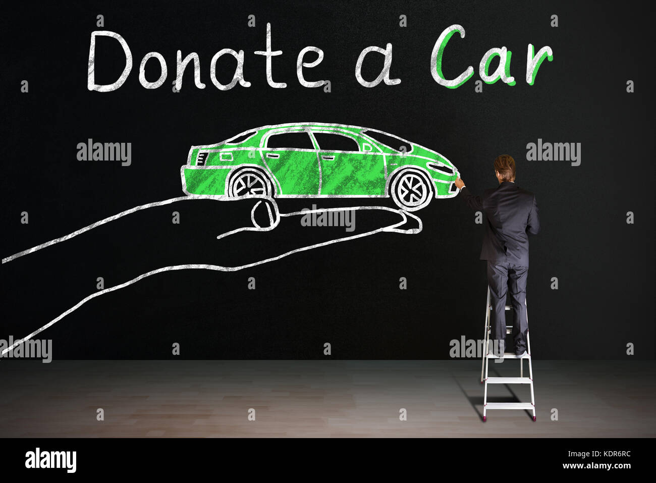 Vue arrière du businessman standing on staircase encombrement la voiture concept de don sur tableau noir Banque D'Images