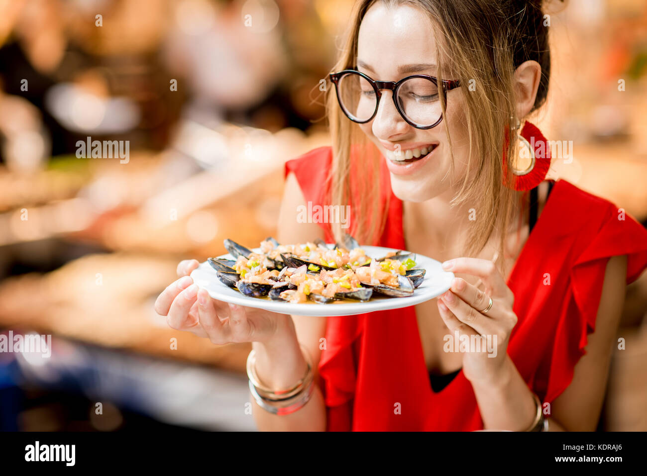 Femme mangé des moules au marché alimentaire Banque D'Images