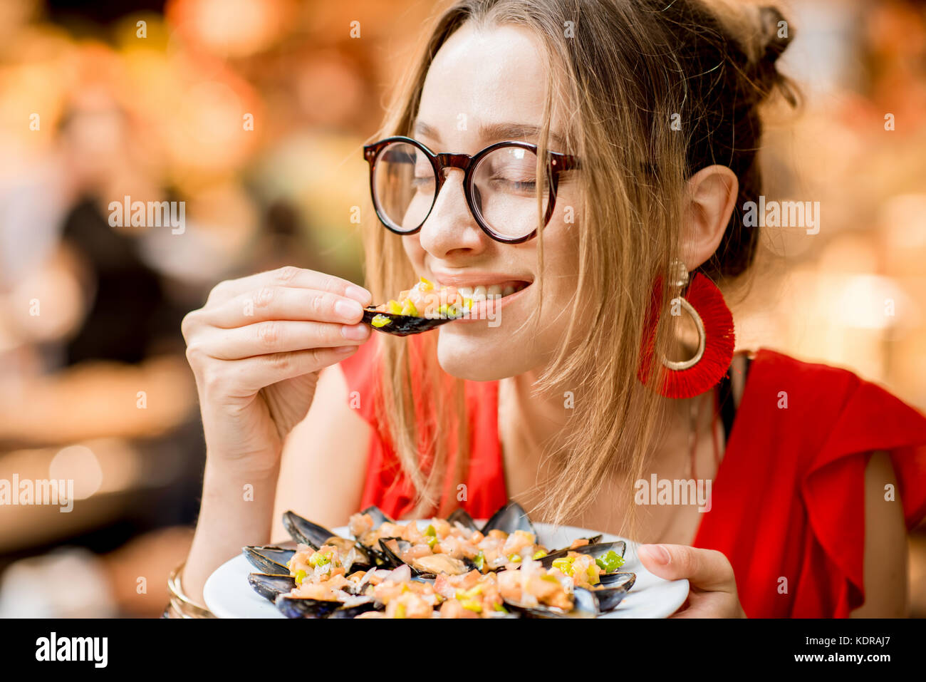 Femme mangé des moules au marché alimentaire Banque D'Images