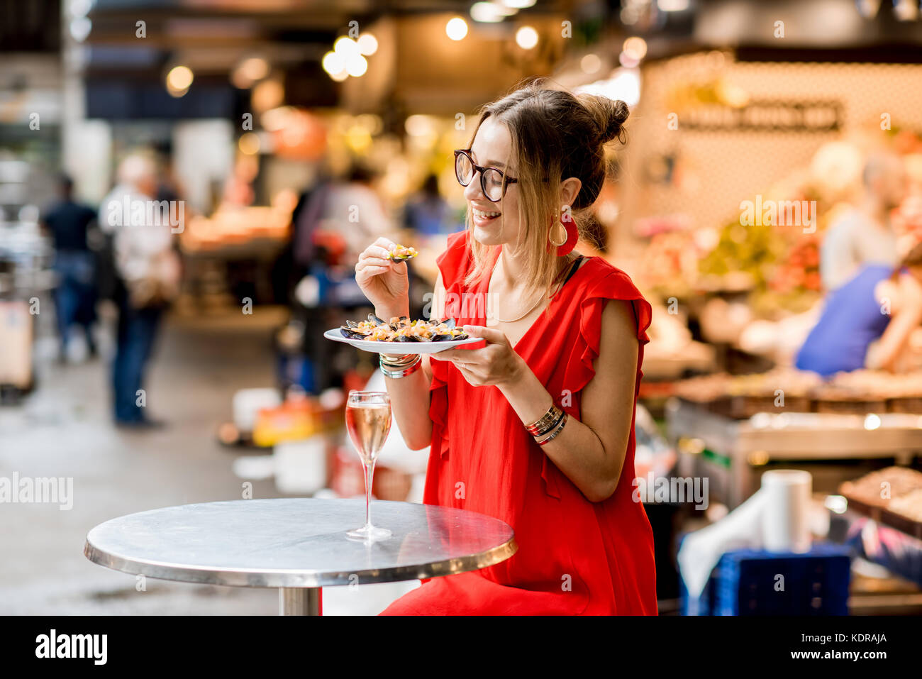 Femme mangé des moules au marché alimentaire Banque D'Images