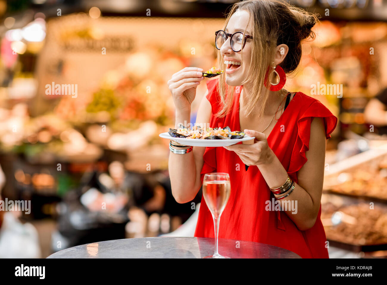 Femme mangé des moules au marché alimentaire Banque D'Images