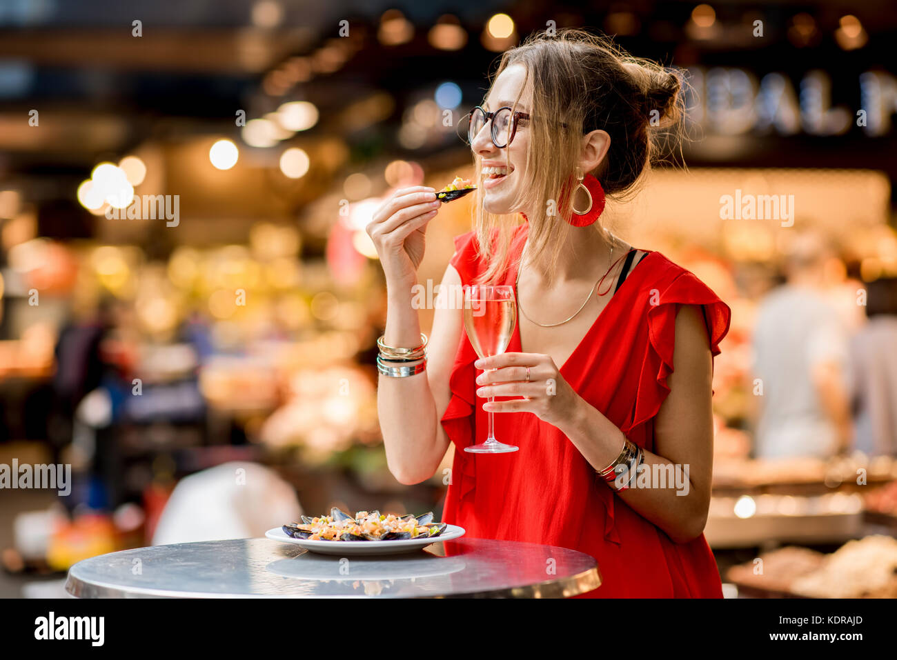 Femme mangé des moules au marché alimentaire Banque D'Images