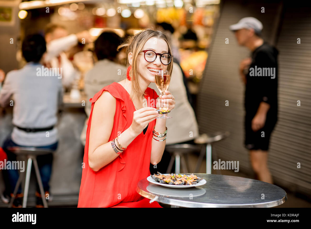 Femme mangé des moules au marché alimentaire Banque D'Images