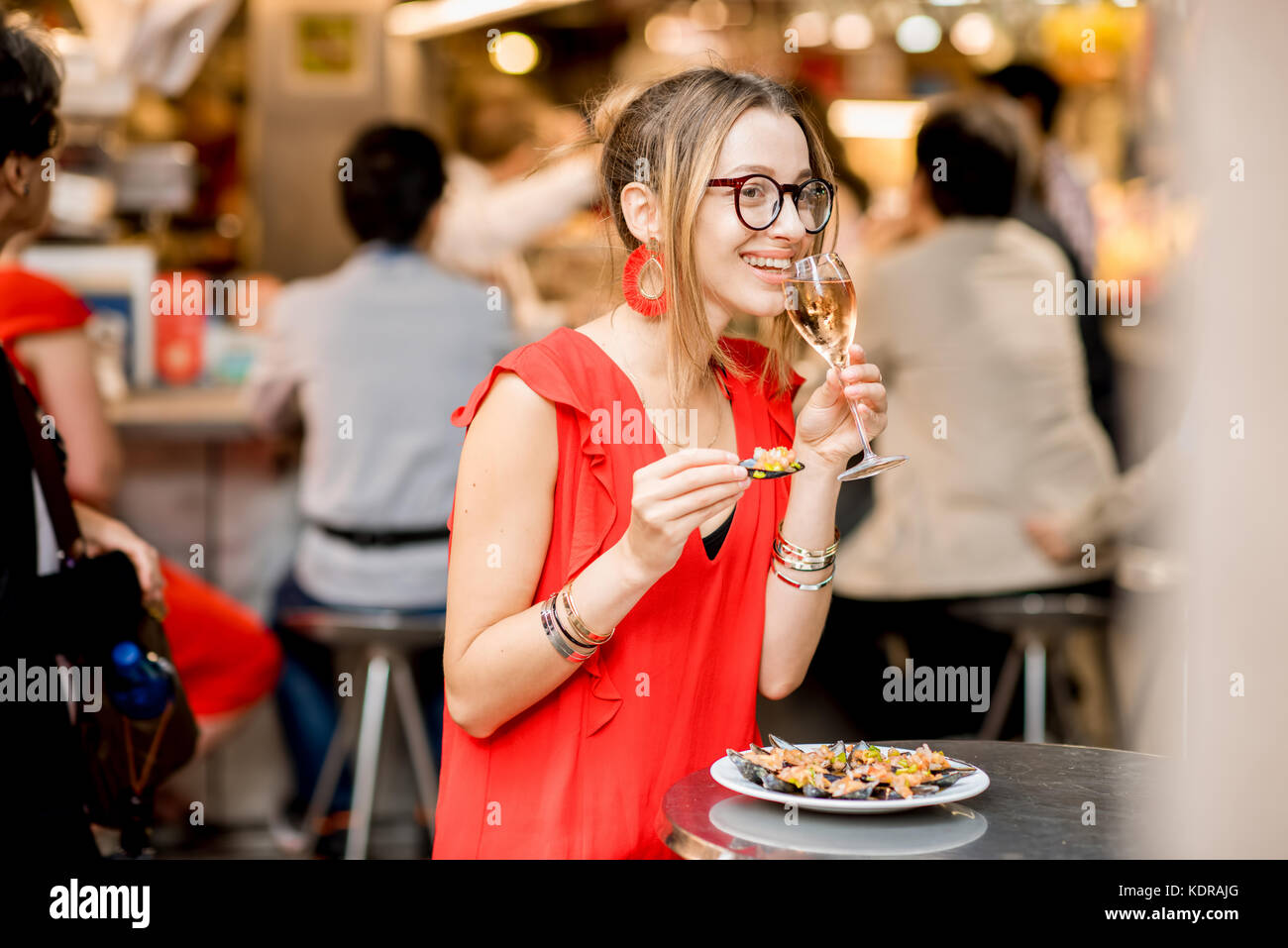 Femme mangé des moules au marché alimentaire Banque D'Images