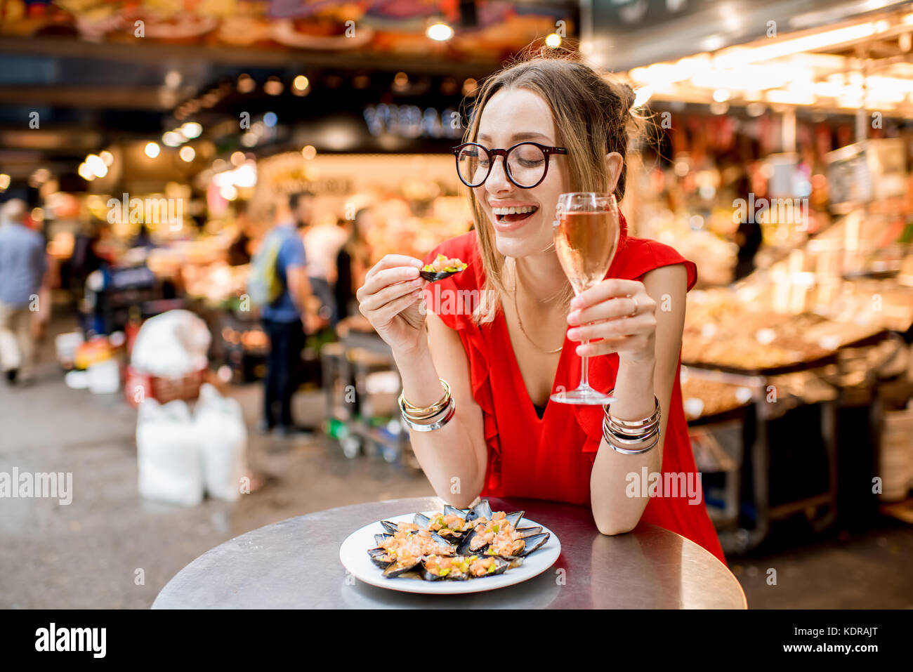 Femme mangé des moules au marché alimentaire Banque D'Images