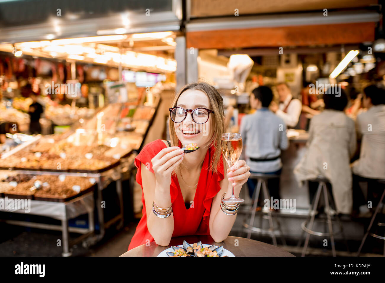 Femme mangé des moules au marché alimentaire Banque D'Images