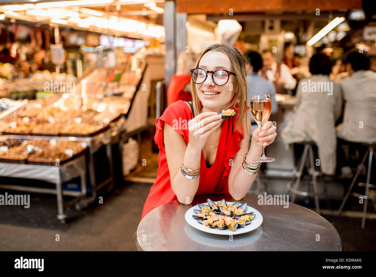 Femme mangé des moules au marché alimentaire Banque D'Images