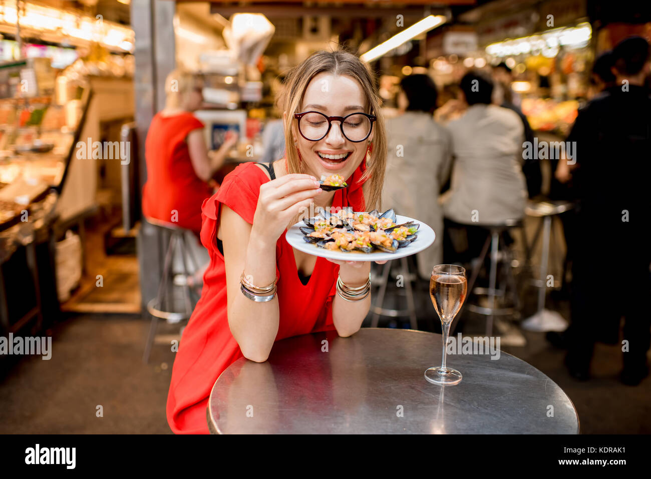 Femme mangé des moules au marché alimentaire Banque D'Images