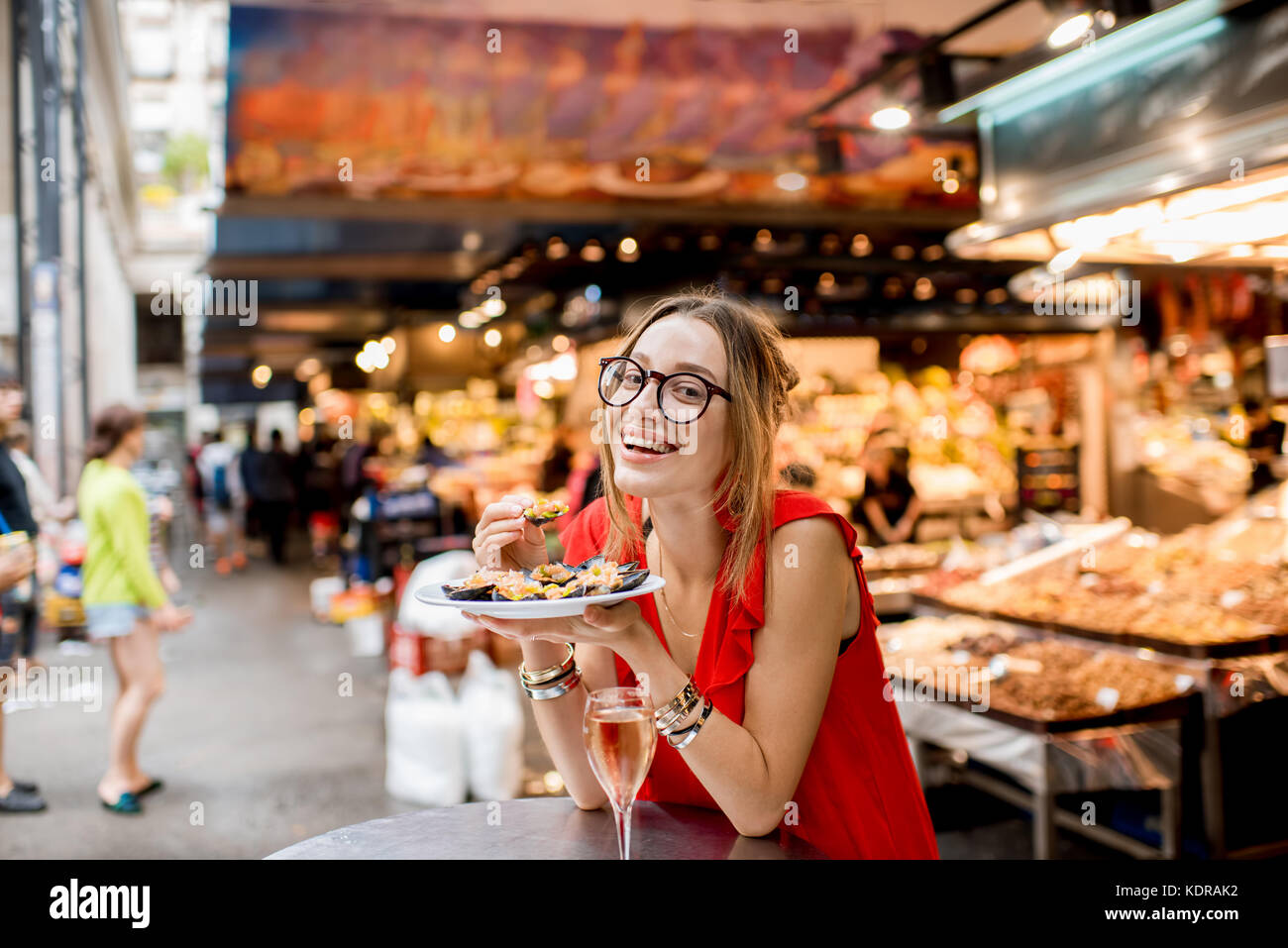 Femme mangé des moules au marché alimentaire Banque D'Images