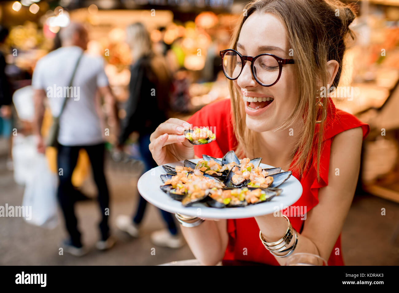 Femme mangé des moules au marché alimentaire Banque D'Images