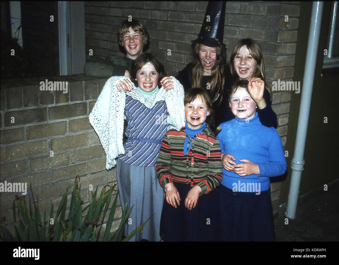 Des années 1980, le temps du soir et un petit groupe d'enfants s'amusant à célébrer Halloween, England, UK. Banque D'Images