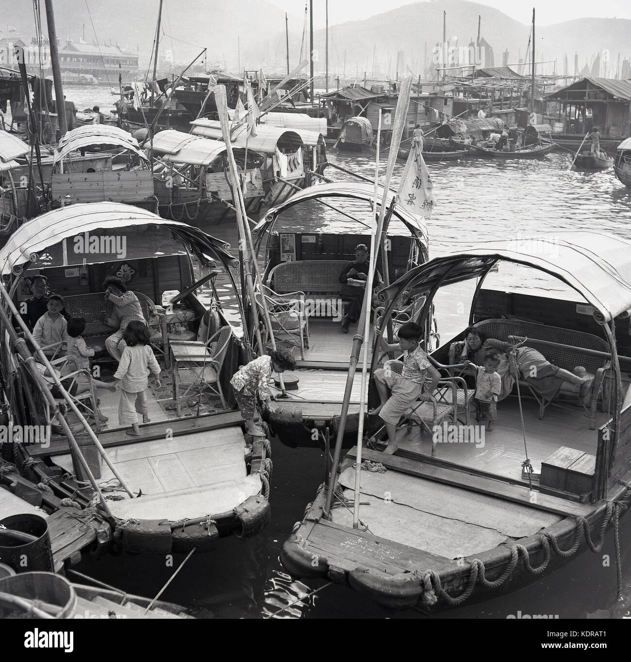 Années 1950, historiques, les mères avec leurs enfants sur leurs junks (bateaux) amarrés au village flottant d'Aberdeen, port d'Aberdeen, Hong Kong. Banque D'Images