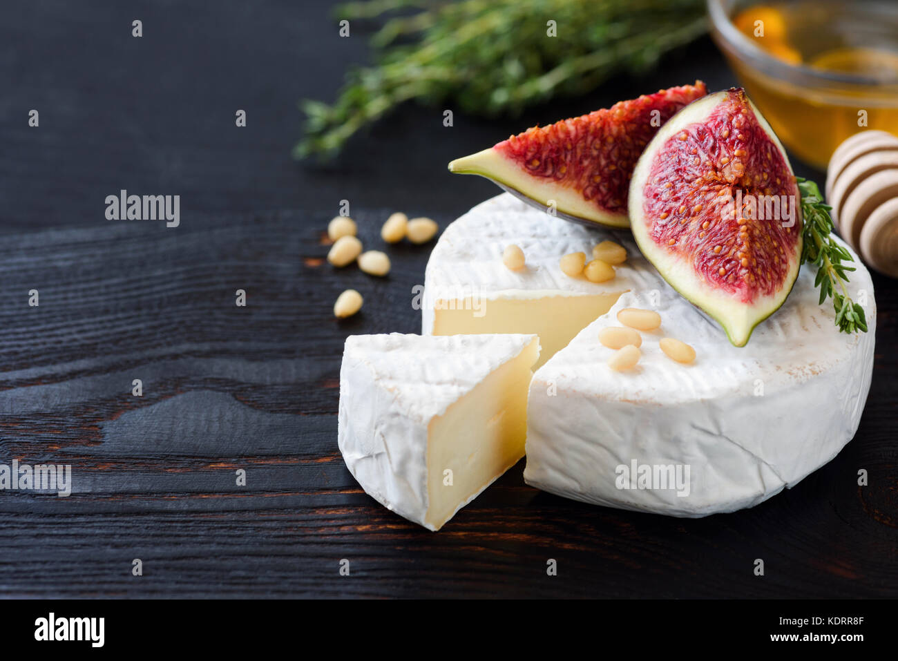 Brie fromage blanc ou fromage apéritif gourmet camambert. plaque avec du fromage blanc, figues, thym, miel et noix Banque D'Images