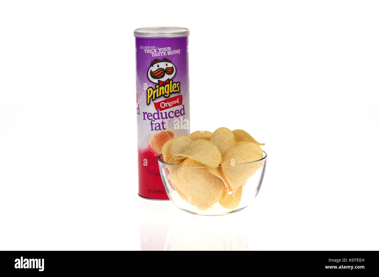 Tube de graisse réduit Pringles chips de pomme de terre d'origine avec des chips dans un bol sur fond blanc découper des USA. Banque D'Images