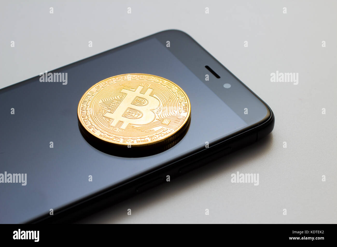 Close-up of a golden monnaie bitcoin et un téléphone intelligent Banque D'Images