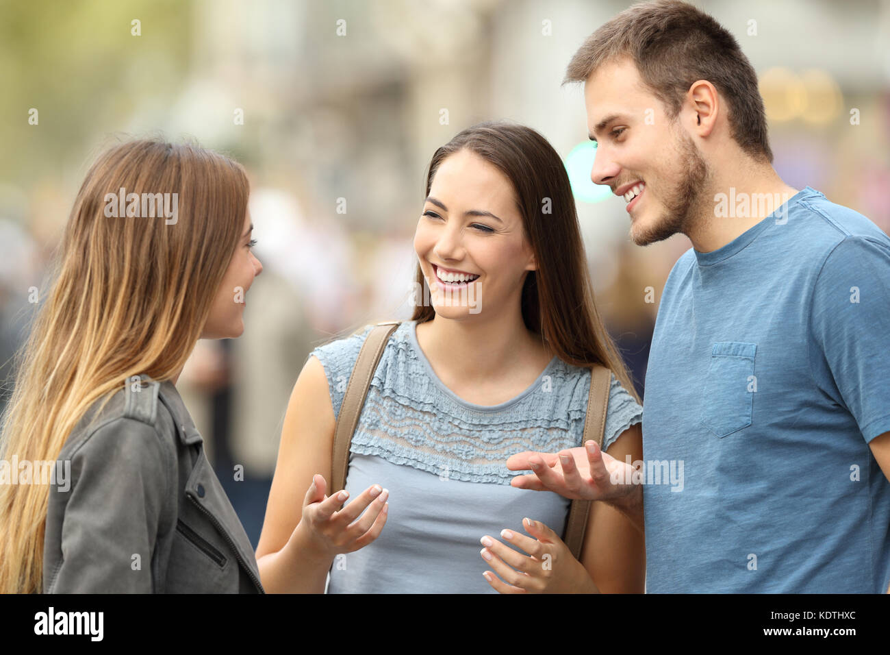 Portrait de trois smiling friends parler ensemble debout sur la rue Banque D'Images
