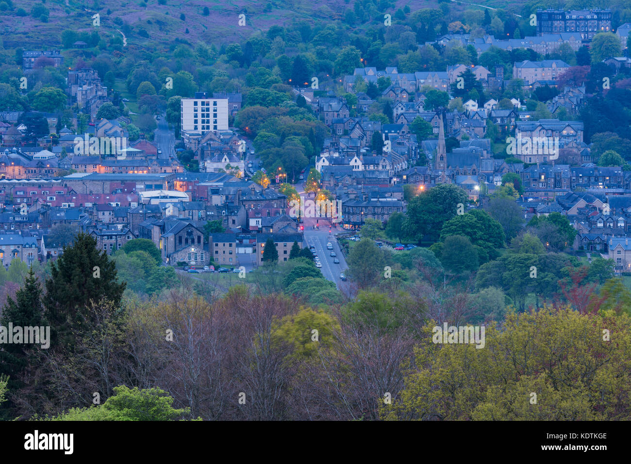 Vue du soir d'Ilkley centre ville nichée dans la vallée de Wharfe - les bâtiments résidentiels, high street, phares sur & moors - West Yorkshire, Angleterre, Royaume-Uni. Banque D'Images