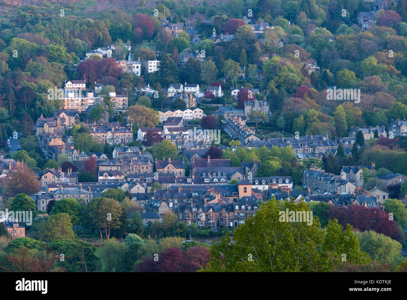 Haut de printemps vue sur colline, blotti dans les bâtiments résidentiels bois coloré dans la vallée Wharfe - Ilkley town, West Yorkshire, Angleterre, Royaume-Uni. Banque D'Images