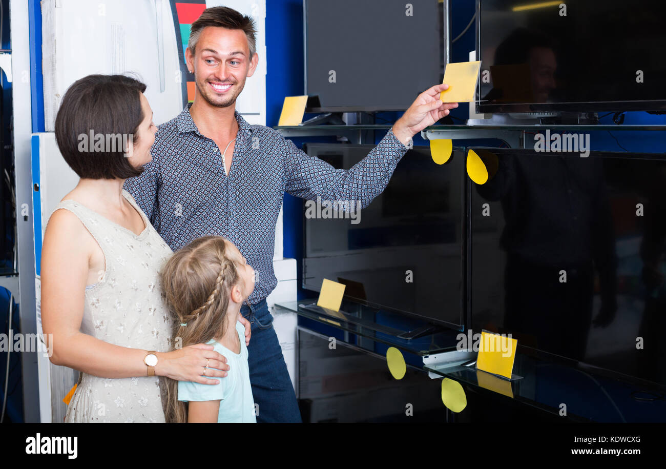 Smiling couple avec petite fille acheter nouveau plat dans la boutique d'électroménager Banque D'Images