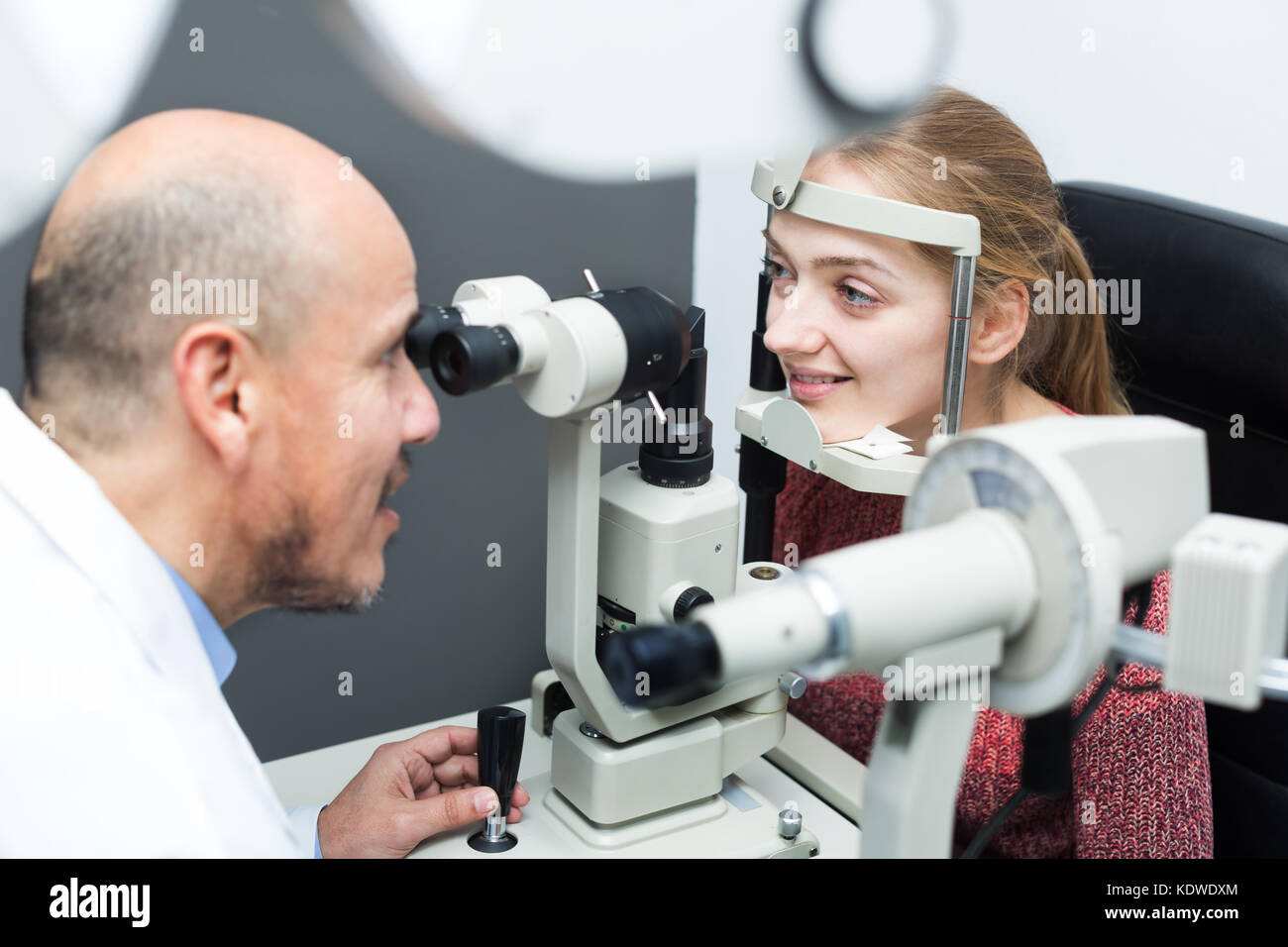 Opticien mature faisant l'examen des yeux à l'aide de la lampe à fente Banque D'Images