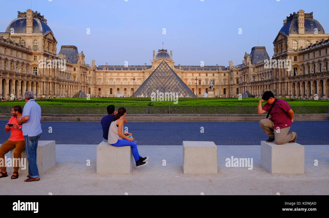 Les touristes se détendre devant le Louvre à Paris, avec un touriste qui se présentent comme le Thinkert Banque D'Images