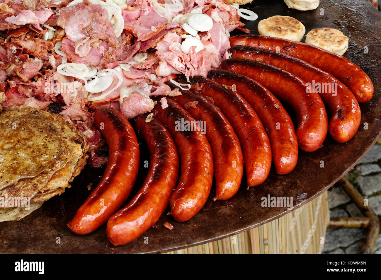 Saucisses grillées, du jambon chaud et des crêpes sur la plaque de métal. Banque D'Images