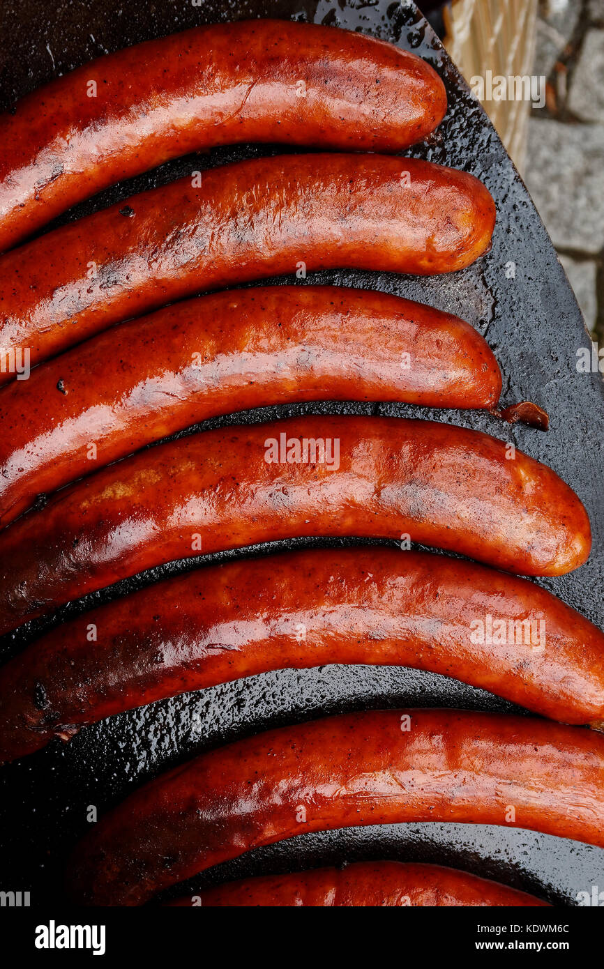 Paprika saucisses Bratwurst sur plaque de fer en fonte à partir de ci-dessus. Banque D'Images