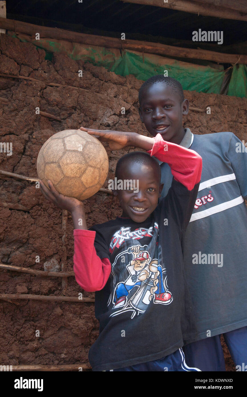 Deux garçons jouent avec un football dans leur orphelinat dans les bidonvilles de Kibera, Nairobi, Kenya, Afrique de l'est Banque D'Images