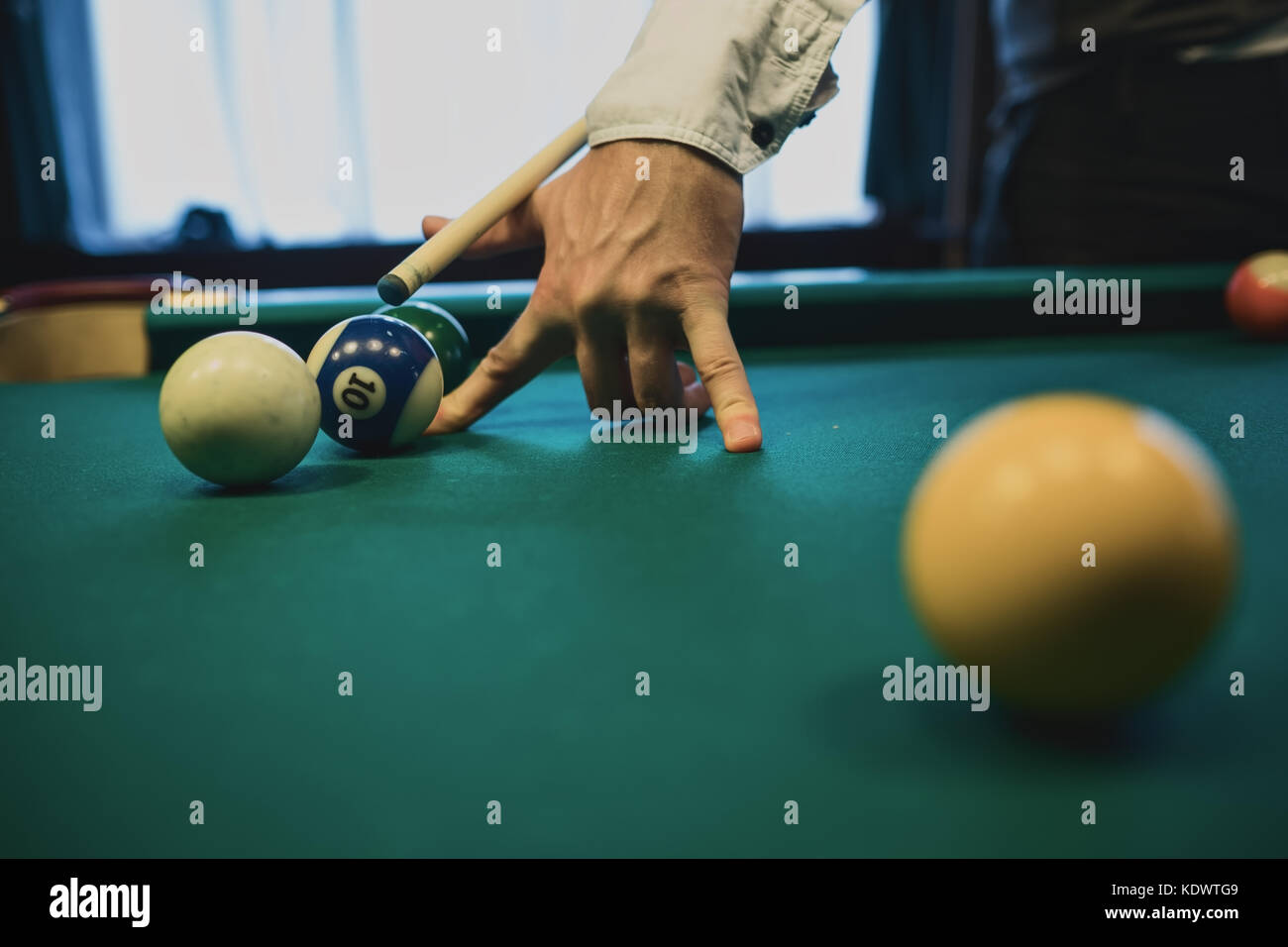 Billard américain. Homme jouant au billard, au snooker. Player s'apprêtait à tourner, frapper la bille blanche. Banque D'Images