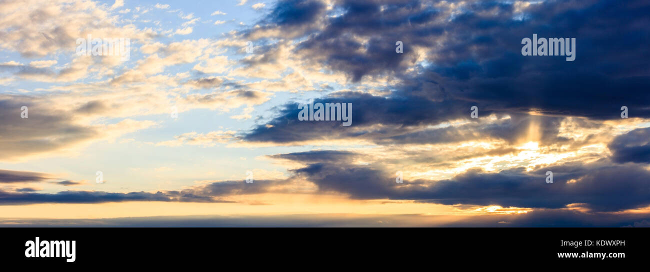 Motif étonnant des nuages dans le ciel au coucher du soleil. Belle, golden rayons de couvrir le ciel. Banque D'Images