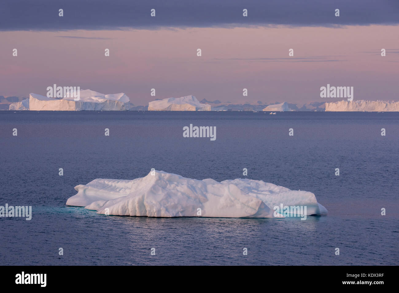 Groenland, Scoresbysund Aka Scoresby Sund, Nordvestfjord. Lever du soleil sur d'énormes icebergs. Banque D'Images