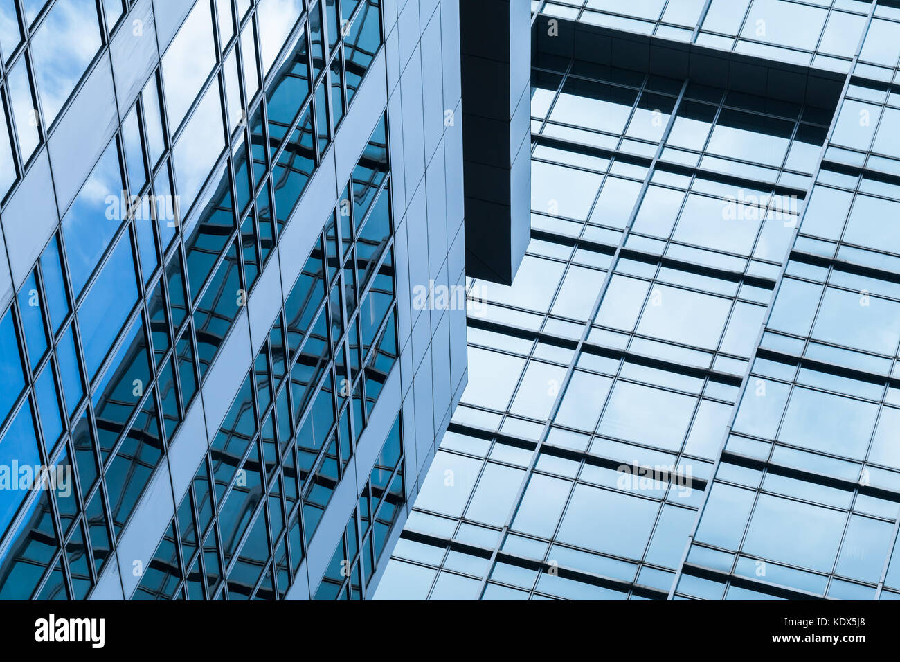 Immeuble de bureaux moderne abstrait fragment d'architecture, des murs en verre et acier avec des reflets de blue cloudy sky Banque D'Images