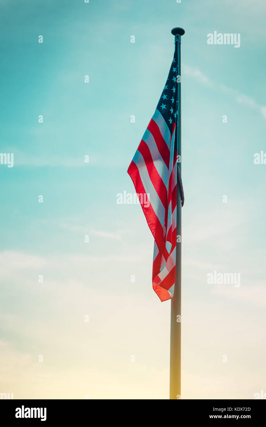 Usa drapeau sur poteau dans le coucher du soleil, american national bannière avec stars and stripes dans la soirée Banque D'Images