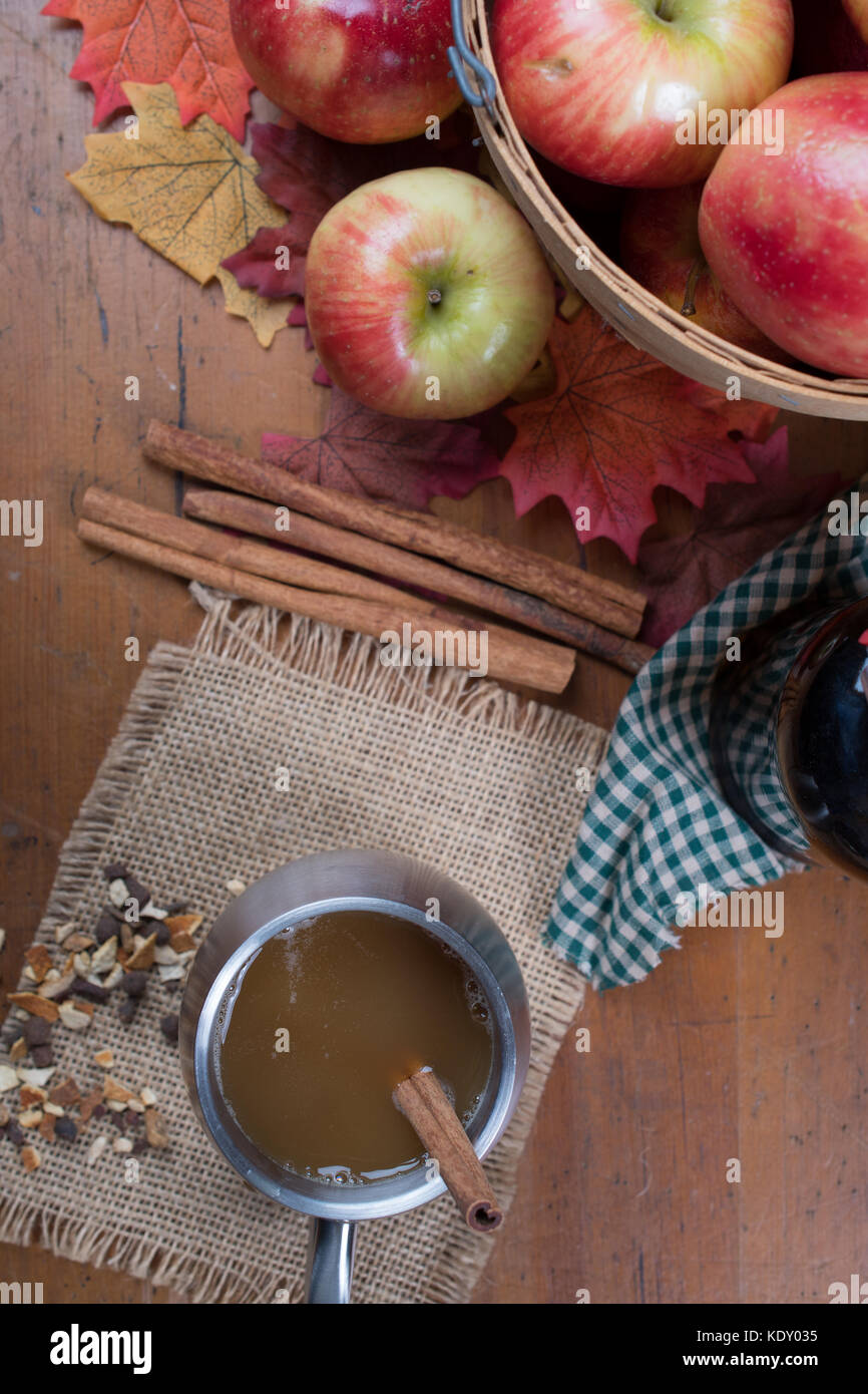 Vue de dessus de cidre dans une tasse à côté d'un panier de pommes. Banque D'Images