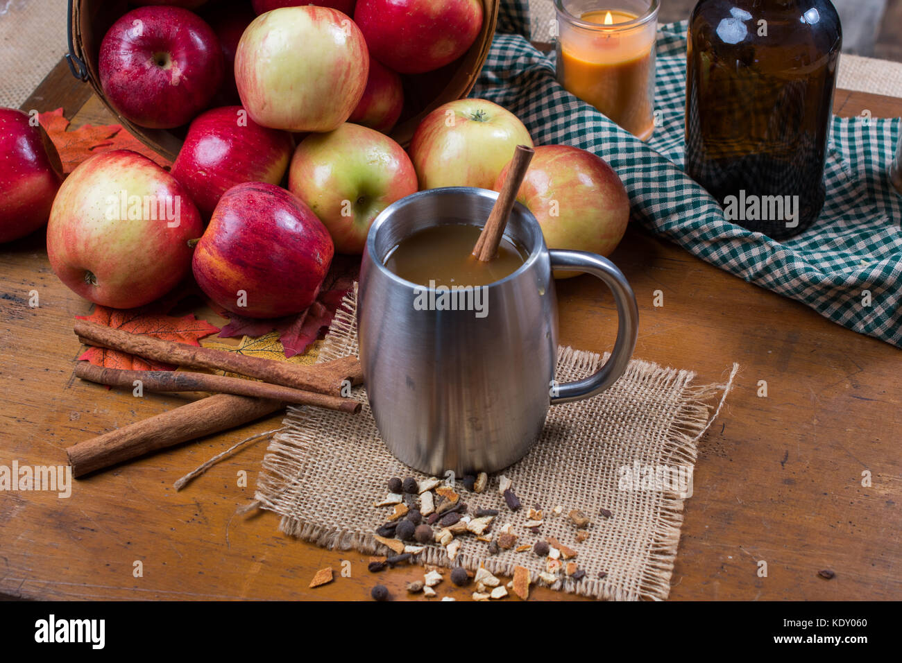 Coupe d'argent avec cidre. les pommes et les bâtons de cannelle sont à l'arrière-plan. tasse se trouve sur la toile de jute avec des épices pour cadre rustique Banque D'Images