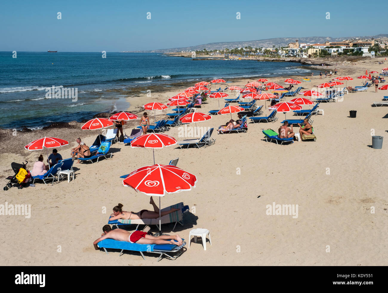 Les vacanciers se prélasser au soleil sur la plage de Kath Municipal de Paphos, Chypre. Banque D'Images